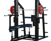 Développé Couché Guidé Excentrique LAROQ noir et bleu sur fond clair. Banc réglable avec logo, rails chromés pour barre guidée, barre olympique montée avec disques bumper rouges 25 kg, supports latéraux et sécurités réglables, vue 3/4.